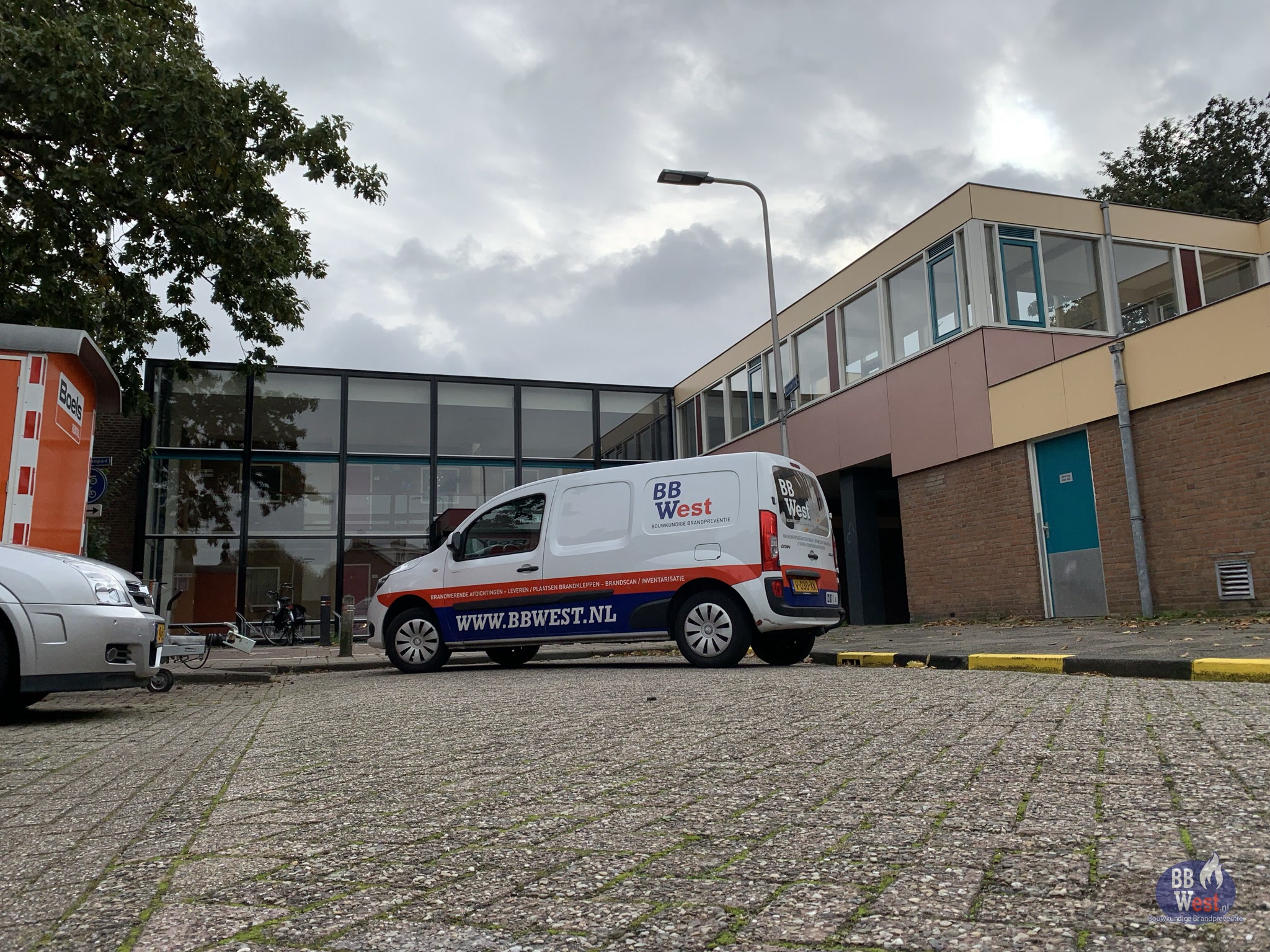 BBWest-bedrijfsbus geparkeerd voor een gebouw